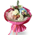 Bouquet of flowers wrapped in pink paper with colorful ribbons on a white background