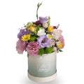 Colorful flower arrangement in a box with 'Be happy' text on a white background