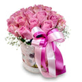 Bouquet of pink roses with a large pink bow in a decorative box on a white background