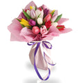 Bouquet of colorful tulips with pink paper and purple ribbon on a white background